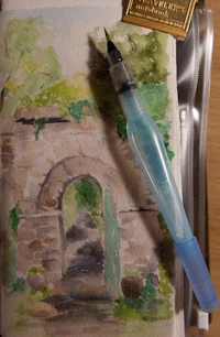 a watercolor sketchbook with a fountain pen next to it