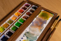 a wooden box filled with paints and brushes