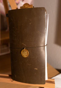 a brown leather journal sitting on a wooden easel